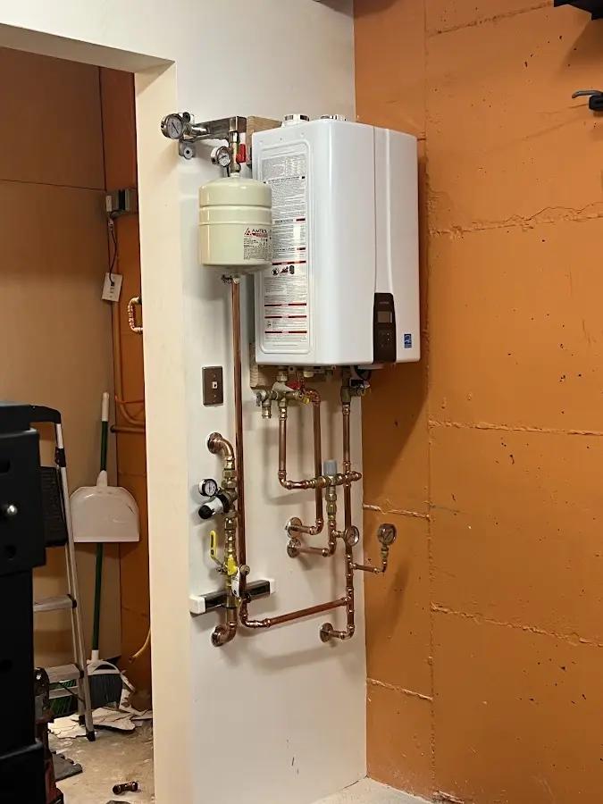 Plumbing technician inspecting water heater connections in Ogden